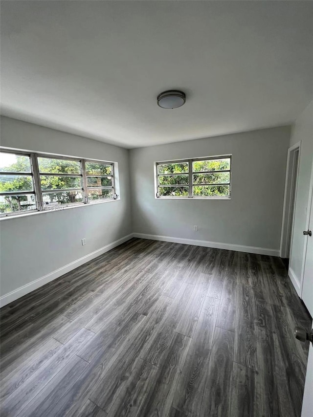 unfurnished room with dark hardwood / wood-style flooring