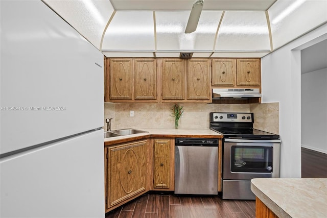 kitchen with stainless steel appliances, dark hardwood / wood-style flooring, tasteful backsplash, and sink