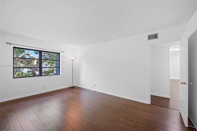 unfurnished room with dark hardwood / wood-style floors and a textured ceiling