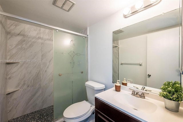 bathroom with a shower with shower door, toilet, and vanity