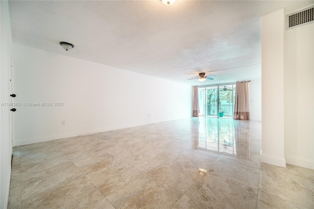 unfurnished room featuring visible vents, ceiling fan, a textured ceiling, and baseboards