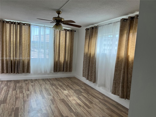 unfurnished room featuring ceiling fan, a textured ceiling, and wood finished floors