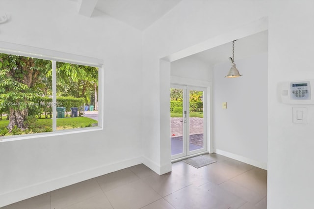 entryway featuring tile patterned flooring and vaulted ceiling