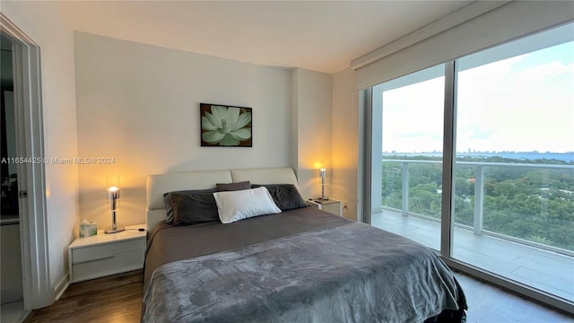 bedroom featuring multiple windows, dark hardwood / wood-style floors, and access to outside