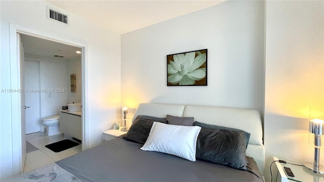 bedroom featuring connected bathroom and light tile patterned flooring