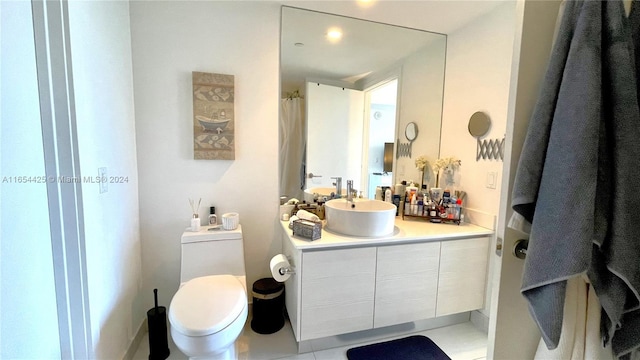 bathroom featuring vanity, toilet, and tile patterned flooring