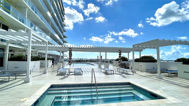 view of swimming pool featuring a community hot tub, a pergola, and a water view