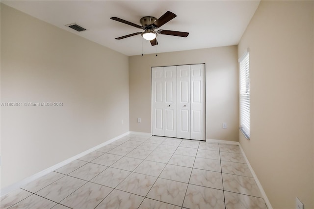 unfurnished bedroom featuring light tile patterned floors, ceiling fan, and a closet