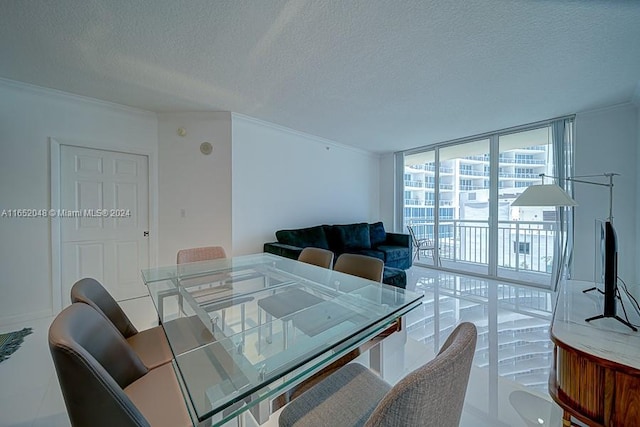 dining space with a textured ceiling, ornamental molding, and a wall of windows