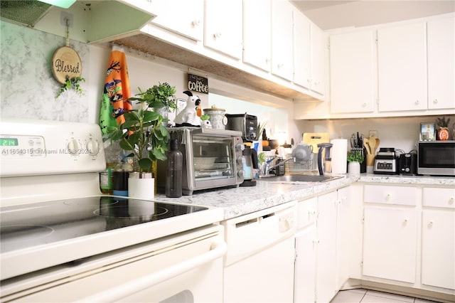 kitchen featuring exhaust hood, white appliances, sink, white cabinetry, and light tile patterned flooring