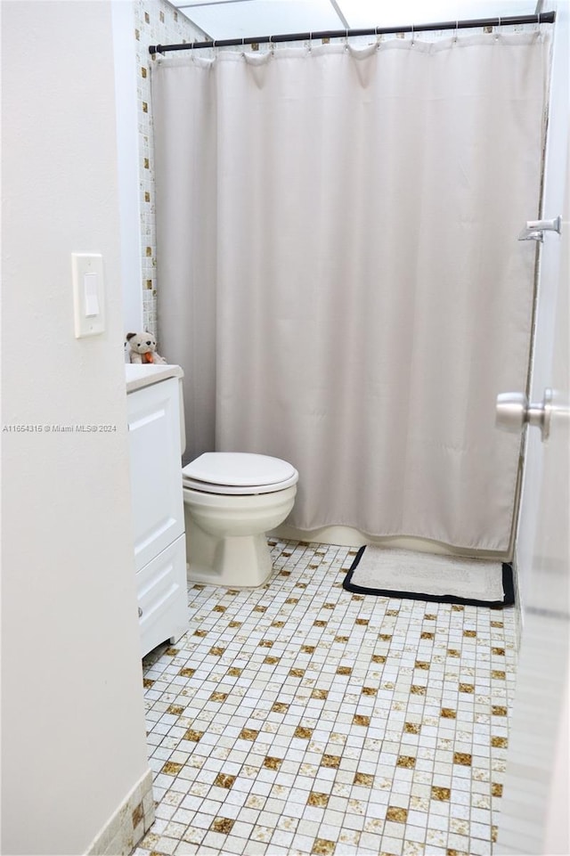 bathroom with vanity, toilet, tile patterned floors, and walk in shower