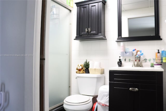 bathroom featuring vanity, toilet, and backsplash