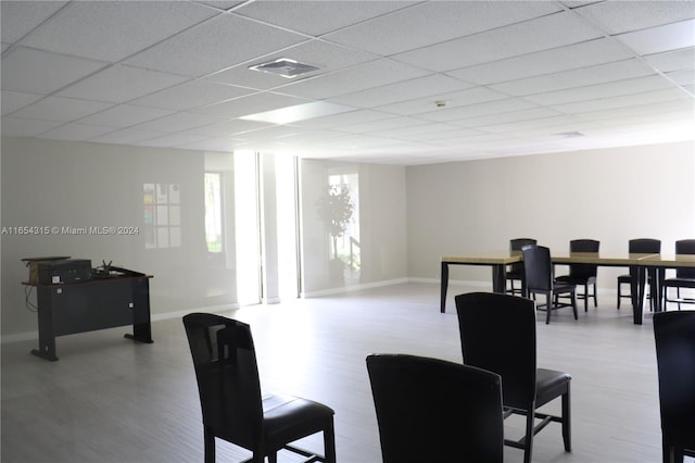 dining room with light hardwood / wood-style flooring and a drop ceiling