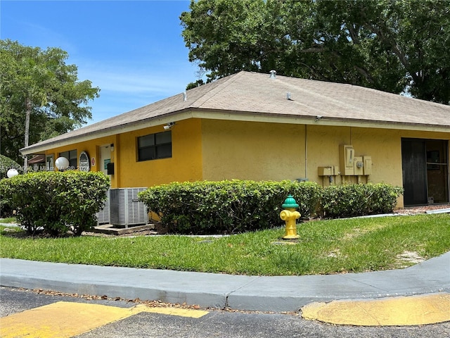 ranch-style home with cooling unit and a front lawn