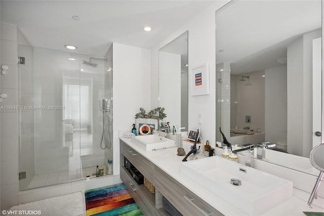 bathroom with a shower with door, vanity, and toilet