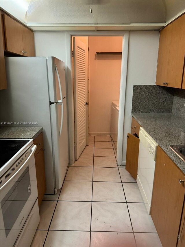 kitchen with dark stone countertops, white dishwasher, sink, ceiling fan, and a textured ceiling