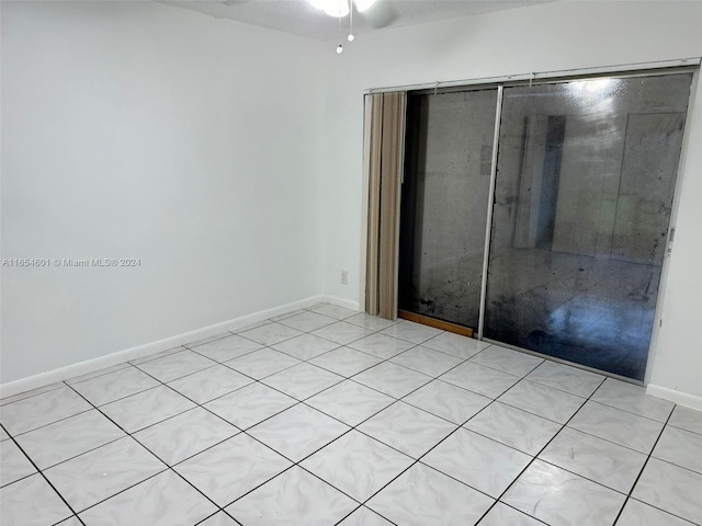 spare room featuring ceiling fan and light tile patterned floors