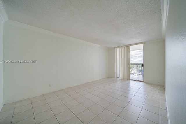 tiled empty room with crown molding and a textured ceiling