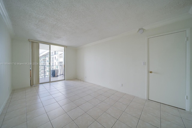 tiled empty room with expansive windows, crown molding, and a textured ceiling