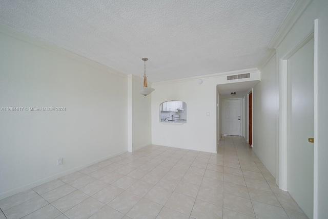 spare room with ornamental molding, a textured ceiling, and light tile patterned floors