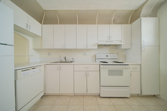 kitchen with white appliances, light tile patterned flooring, sink, and white cabinets