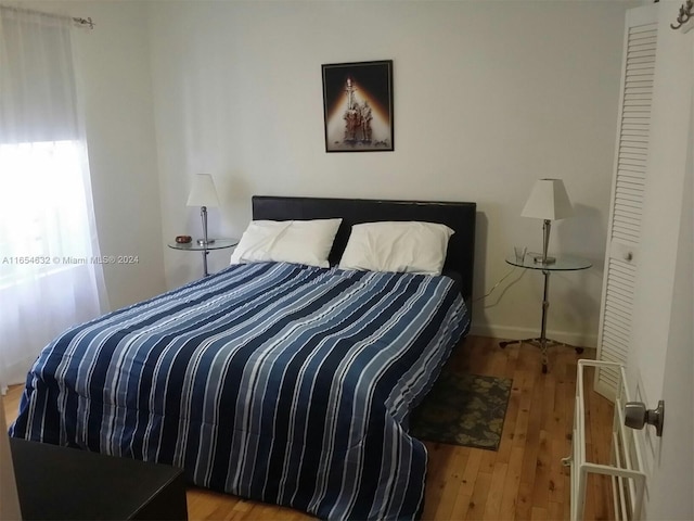 bedroom featuring hardwood / wood-style floors and a closet