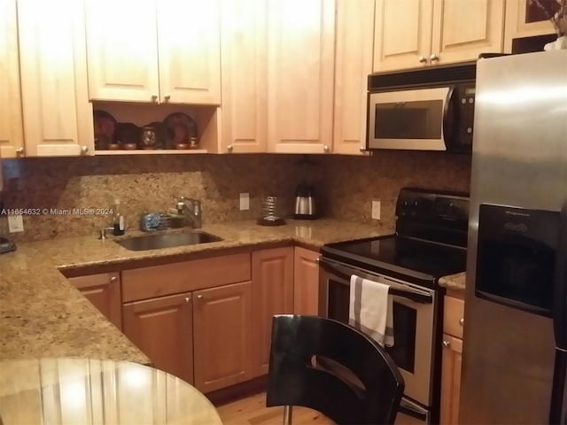 kitchen with white cabinets, light stone countertops, stainless steel appliances, sink, and decorative backsplash