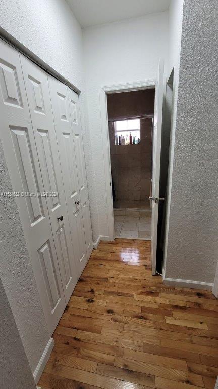 corridor with wood-type flooring