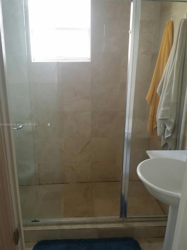 bathroom featuring a shower with shower door