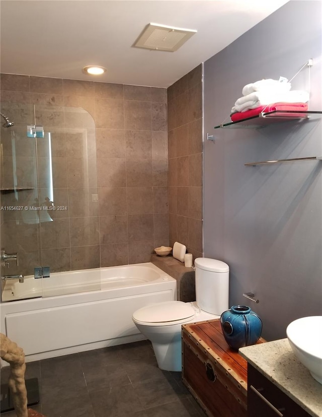 full bathroom featuring tile patterned flooring, vanity, toilet, and tiled shower / bath combo