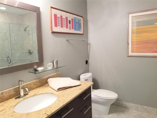 bathroom with vanity, toilet, a shower, and tile patterned flooring