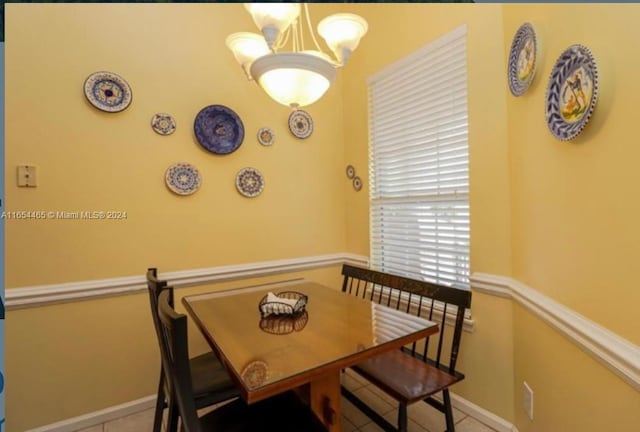 tiled dining room with an inviting chandelier