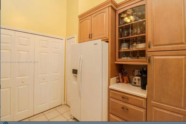 kitchen featuring light tile patterned flooring, white fridge with ice dispenser, and ceiling fan