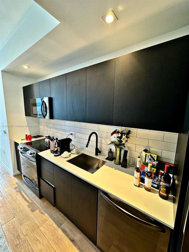 kitchen with dishwasher, range with electric cooktop, sink, and backsplash