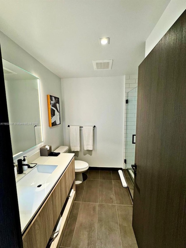 bathroom with walk in shower, vanity, and toilet