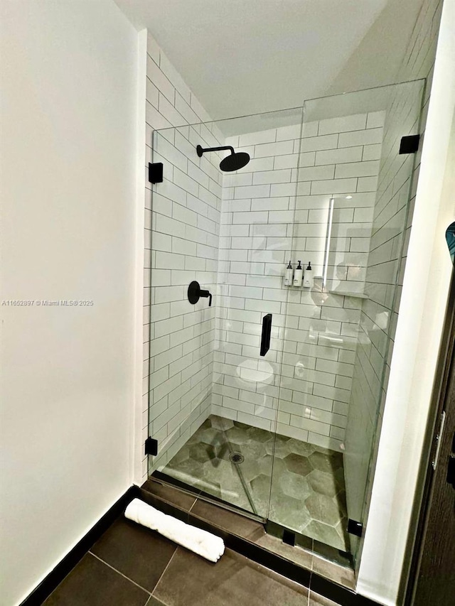 bathroom with tile patterned flooring and a shower with shower door