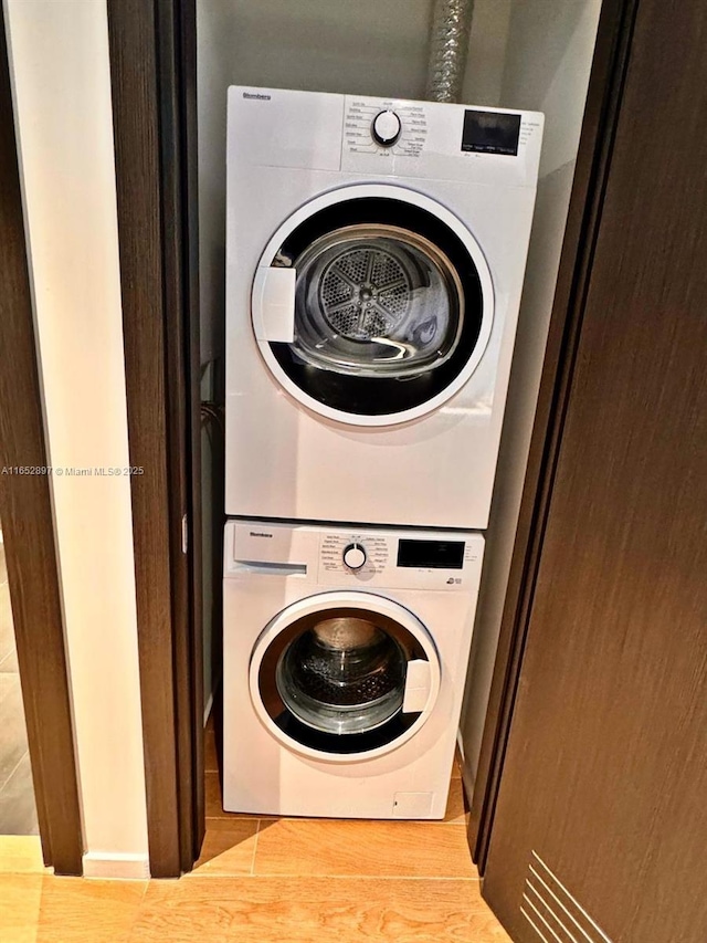 washroom featuring stacked washer and dryer and light hardwood / wood-style floors