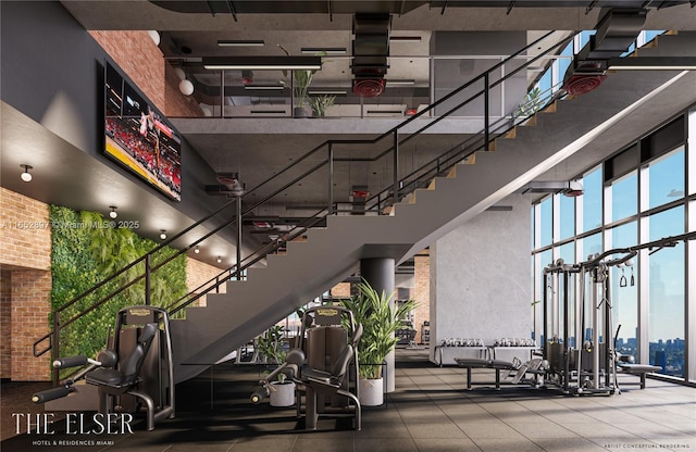 gym featuring a towering ceiling and floor to ceiling windows