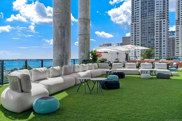 exterior space featuring a water view, an outdoor hangout area, and a lawn