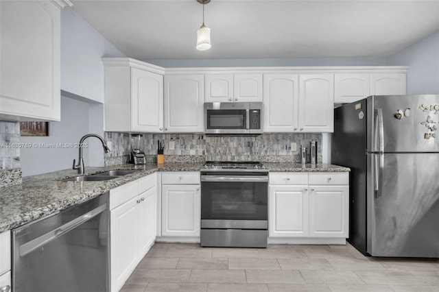 kitchen with stone counters, sink, decorative light fixtures, white cabinetry, and stainless steel appliances