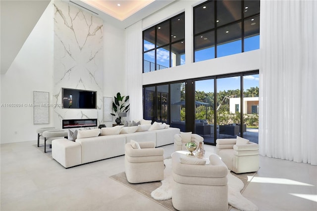 living room with a high end fireplace and a high ceiling