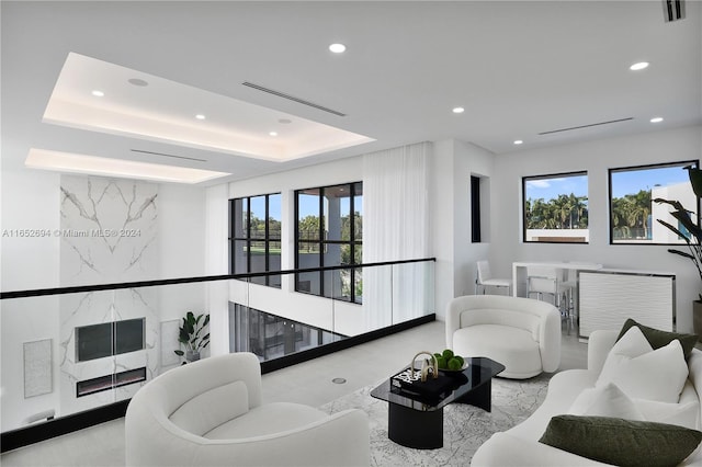 living room with a tray ceiling and plenty of natural light