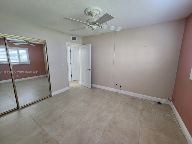 unfurnished bedroom featuring light tile patterned flooring, baseboards, a ceiling fan, and visible vents