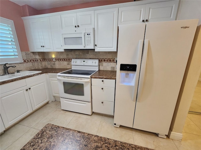 kitchen with tasteful backsplash, white cabinetry, dark countertops, and white appliances