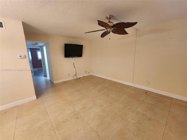 unfurnished room featuring visible vents, baseboards, light tile patterned floors, a ceiling fan, and a textured ceiling