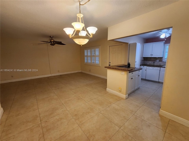 kitchen with white cabinetry, backsplash, dark countertops, and white dishwasher