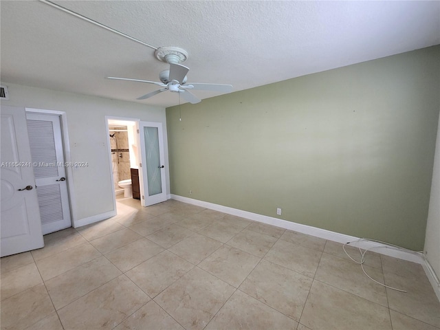 unfurnished bedroom featuring light tile patterned floors, baseboards, visible vents, a ceiling fan, and a textured ceiling