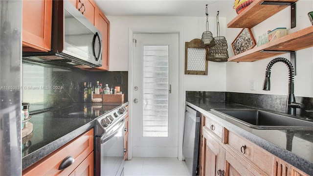 kitchen with appliances with stainless steel finishes, light tile patterned flooring, and sink