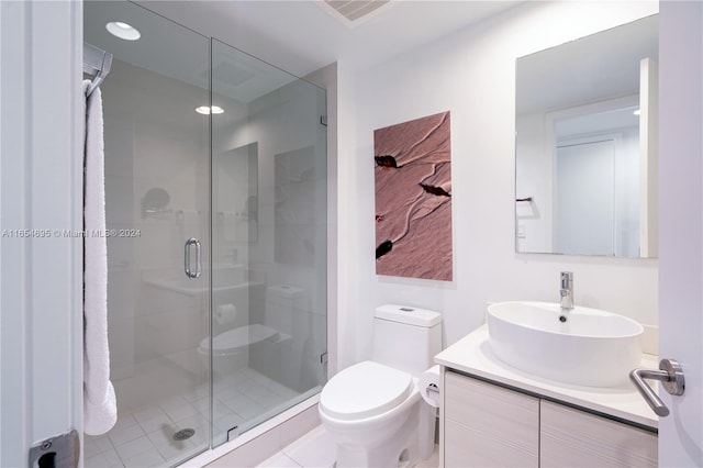 bathroom with vanity, toilet, tile patterned floors, and a shower with door