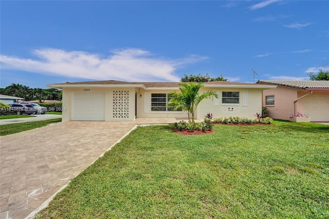 single story home featuring a garage and a front lawn